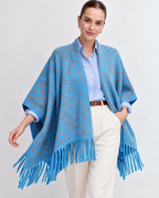 Front view of the Marita Poncho Cape in Blue, with grey zigzag stripes and long fringe over a pale shirt.