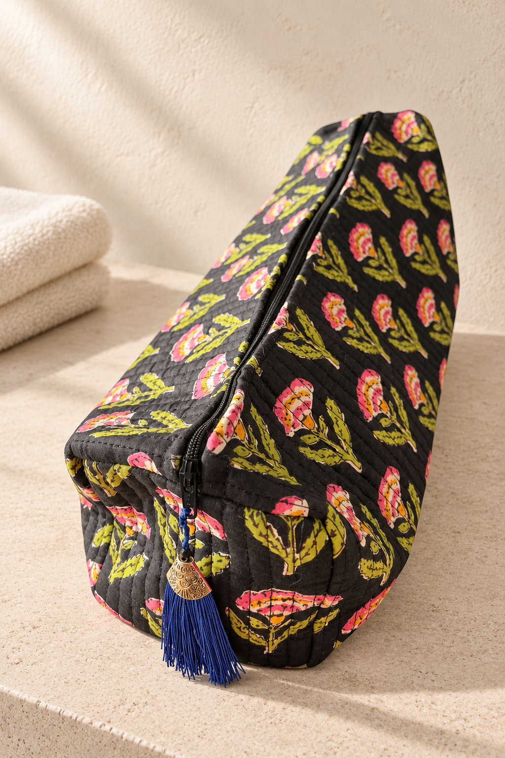 Maison de Belle Grand Wash Bag in Black Bloom, quilted black cotton with pink and lime block-printed flowers and a blue tassel