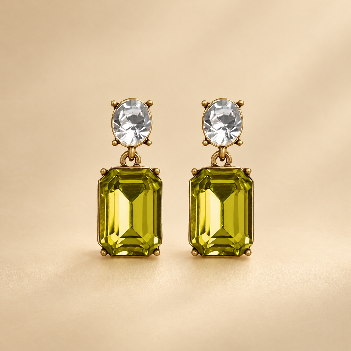 Olive and Clear Oval Twin Gem earrings on a minimal light golden studio background, clear oval studs and olive-green rectangular drops
