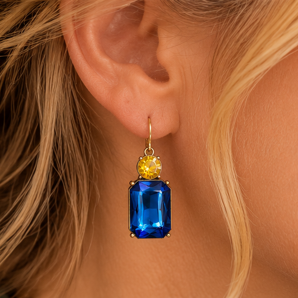 Detailed view of yellow round and azure-blue rectangular drop earring worn on a mature woman's ear