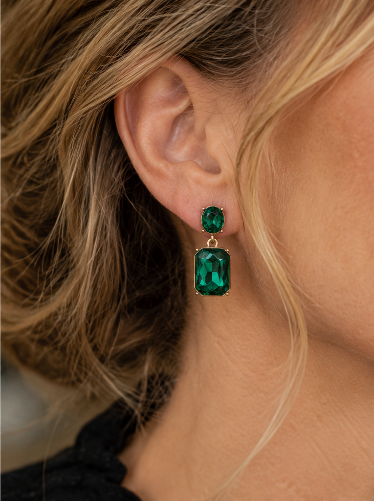 Close-up of Emerald Twin Gem drop earring worn with natural skin texture and warm studio lighting