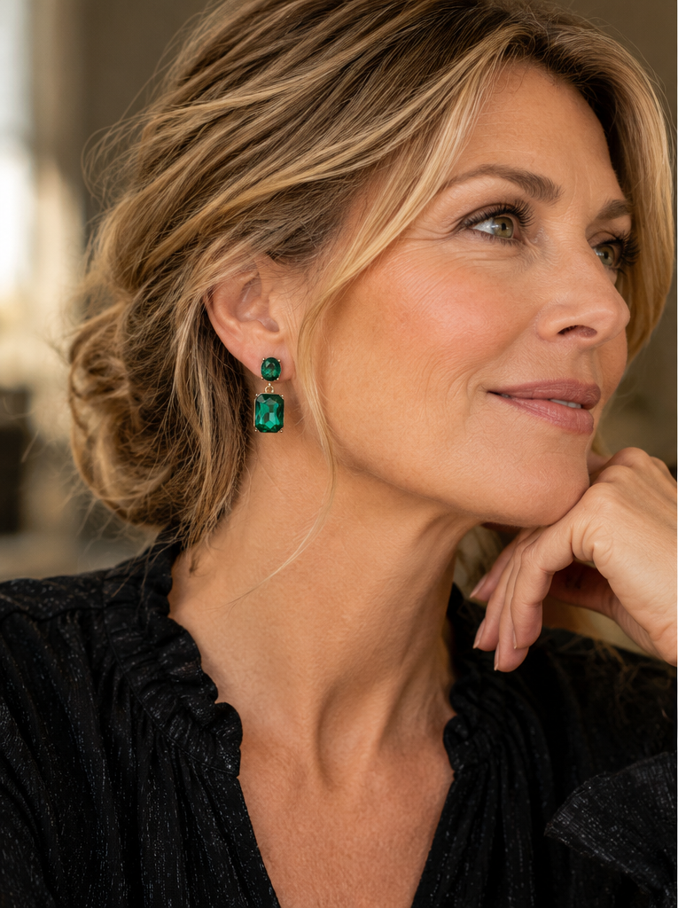 Woman wearing Emerald Twin Gem drop earrings with black blouse in natural editorial portrait