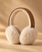 EMU Australia Angahook chestnut suede earmuffs with pale cream sheepskin ear cushions in a warm golden minimalist studio